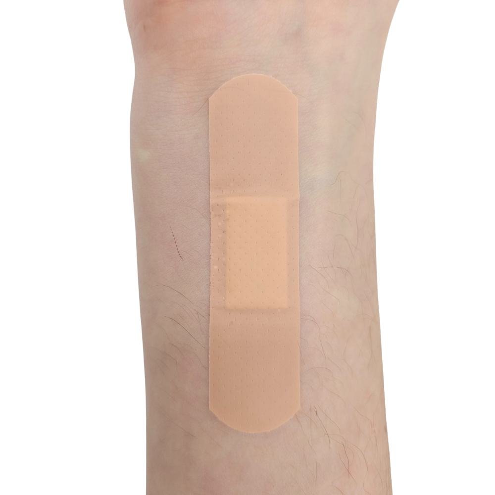 Parche curita Curaplast aplicado en piel brazo mostrando uso real y tamaño referencia venda adhesiva rectangular