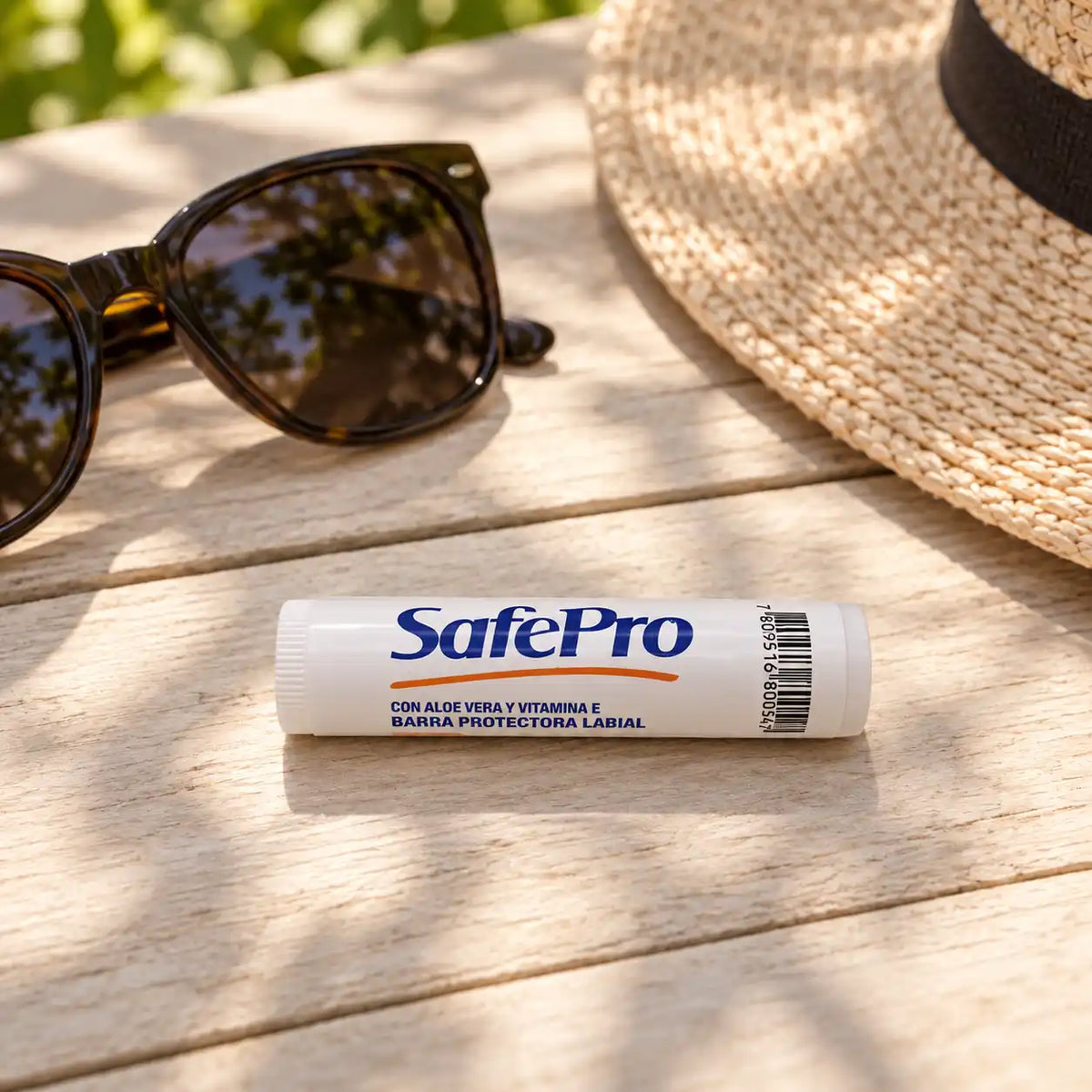 Protector solar labial SafePro junto a lentes y sombrero — kit de protección solar