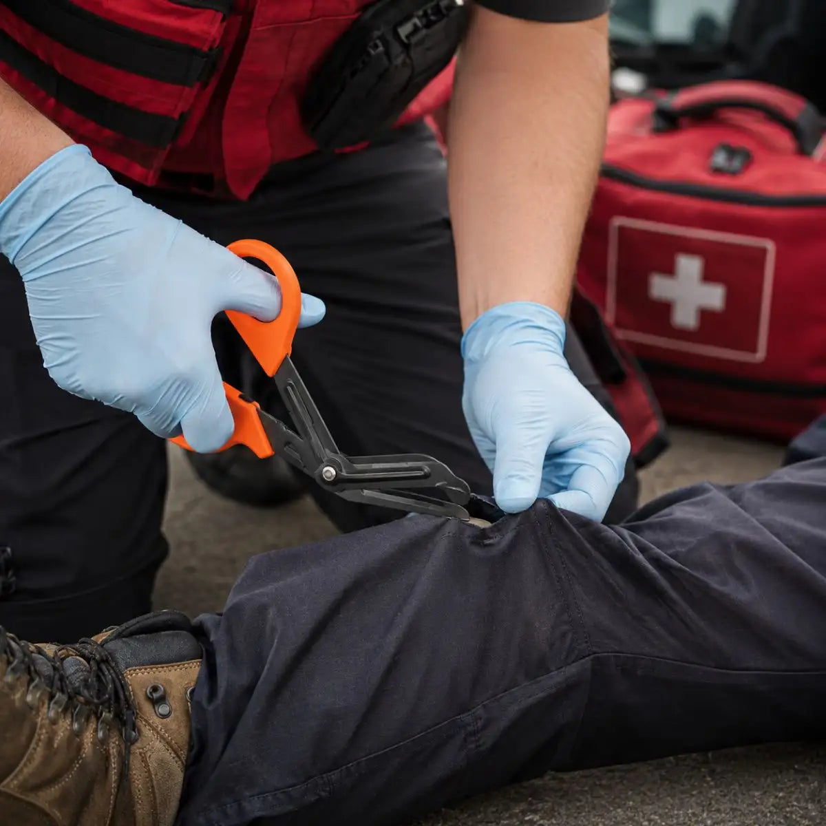 Tijera de trauma en uso — paramédico cortando la ropa de un paciente en emergencia
